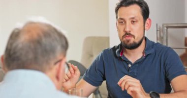 Aile dostu çocuk babasıyla masada konuşuyor, birlikte kahvaltı ediyorlar.