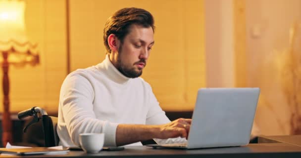 Entrepreneur homme d'affaires concentré en tapant en fauteuil roulant sur ordinateur portable faire de la recherche Jeune professionnel masculin en utilisant — Video