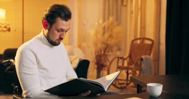 Genç ve engelli bir adam rahat tekerlekli sandalyede oturuyor ve rahat bir gün geçiriyor.