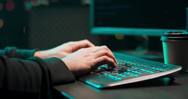 Close up of a young male hackers hands writing malware on a computer keyboard in — Stock Video