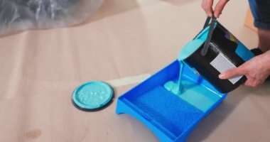 Duvarları boyamaya hazırlanan yeşil zeytin boyası döken Kafkas genç yakışıklı adama yaklaş. 