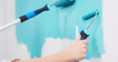 Evi dekore ederken duvar boyayan çift. Apartman dekorasyonu ve tadilat sırasında ev inşaatı 