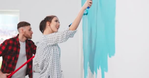 Крупный план портрета веселой молодой пары женщина и мужчина в новой квартире ремонт комнаты — стоковое видео