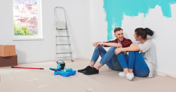 Χαριτωμένο ζευγάρι κόλλα πέντε μετά τη ζωγραφική στο νέο σπίτι, ευτυχισμένη βελτίωση του σπιτιού. — Αρχείο Βίντεο