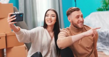 Güzel beyaz bir çift selfie çekip cep telefonuyla ahşap üzerinde video çekiyor. 