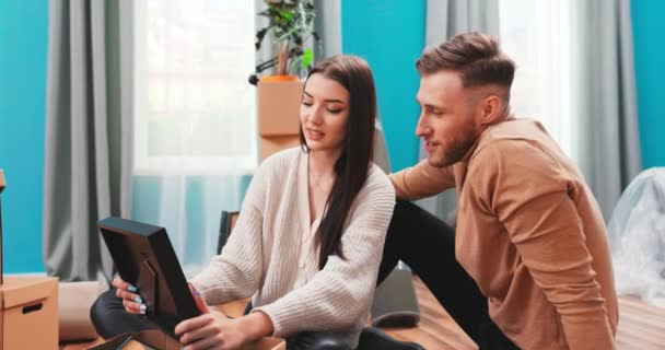 Coppia mossa a nuova casa togliere effetti personali disfare da scatole di cartone tiene frame look — Video Stock