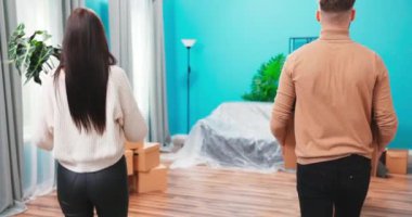 Mutlu genç çift kutuları masaya koyuyor, taşınma gününü kutluyorlar. Neşeli adam. 