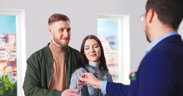 Zblízka pohledný šťastný běloch realitní makléř dává klíče pro nový byt — Stock video