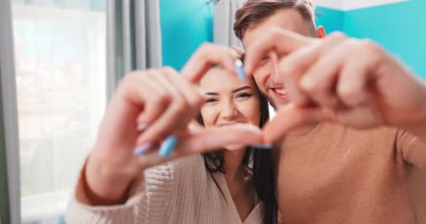 Boldog romantikus pár, akik ujjal mutogatják a szívüket. Szerelem van a levegőben. — Stock videók