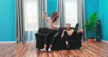 Mutlu genç bir çift yeni evlerine bir kanepe getiriyor. Otururlar.