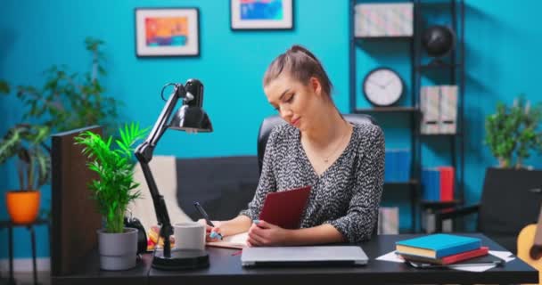 一个漂亮的少女在笔记本上写笔记.一个年轻貌美的黑发女人 — 图库视频影像