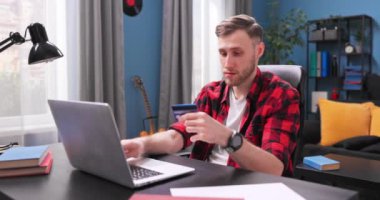 Yakışıklı öğrenci bir internet sitesinde kredi kartı numarası yazıyor. Genç bir adam.