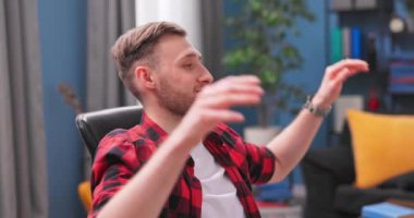 Odasındaki sandalyede rahatça oturan ergen bir çocuğun portresi. Gençler