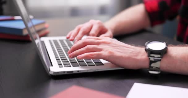 Close-up de mãos de menino adolescente digitando no teclado do laptop. Um jovem com um — Vídeo de Stock