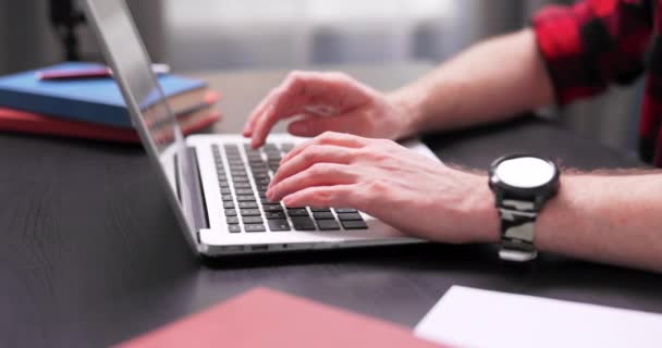 Close-up van tienerjongens handen typen op laptop toetsenbord. Een jongeman met een — Stockvideo