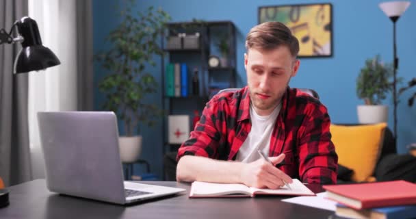 Un estudiante universitario enfocado está conversando en video en una computadora portátil. Un adolescente masculino en — Vídeos de Stock