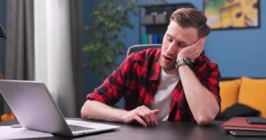 Yorgun ve sıkılmış genç bir öğrenci esniyor ve koltukta uyuyakalıyor.