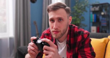 Mutlu genç adam bilgisayarda oyun oynuyor ve kazanıyor. Oyuncuların ön görünümü