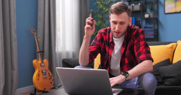 Un adolescent portant une chemise à carreaux en flanelle tape sur le clavier d'un ordinateur portable. Un étudiant masculin — Video