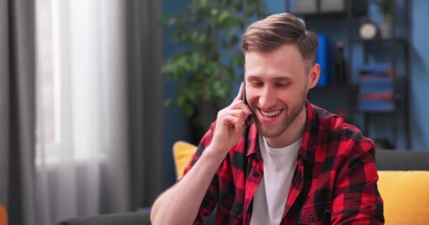 Um estudante do sexo masculino recebe um telefonema de um amigo. Jovem bonito fala sobre — Vídeo de Stock