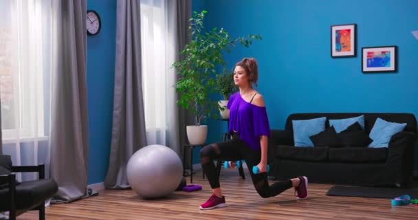Vy av sportig tjej gör utfall tränar benmusklerna och glutes i loft interiör — Stockvideo