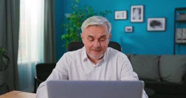 Yaşlı orta yaşlı iş adamı dizüstü bilgisayarla çalışıyor, yaşlı yetişkin adam internet bankacılığı faturalarını ödüyor.