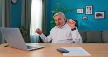 Profesyonel yetişkin kreatif direktör, çalışma odasında masasında oturuyor.