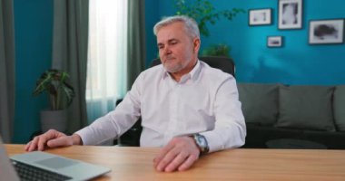 Profesyonel yetişkin kreatif direktör, çalışma odasında masasında oturuyor.