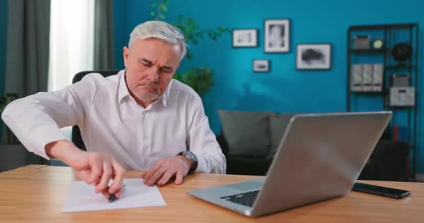 Graves mayores de 60 años hombre de negocios profesional escribiendo notas y análogos finansiales. Anciano usando laptop — Vídeos de Stock