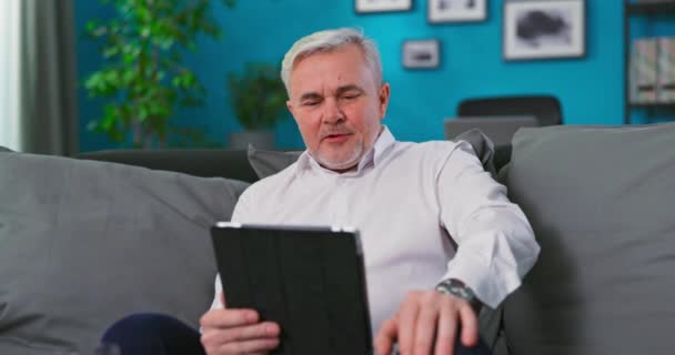Starszy mężczyzna rasy kaukaskiej na wideo czacie z krewnymi lub konsultacji z lekarzem podczas samoizolacji, za pomocą — Wideo stockowe