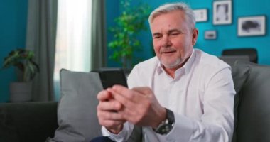 Kumar oynayan yaşlı 60 'lı yaşlarda cep telefonu kullanıyormuş. Akıllı telefon kullanıyormuş.