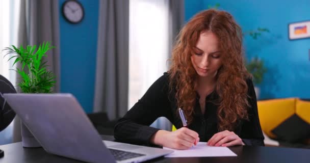 Smart Teenage Girl utilise un ordinateur portable pour un appel vidéo avec son professeur. Belle femelle assise à — Video