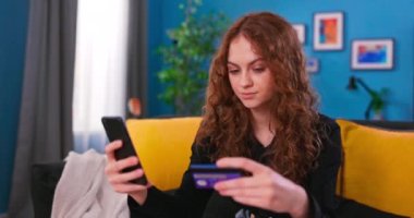 Parlak Güneşli Oturma Odasında Akıllı Telefon Kullanan Güzel Kadın. Faturasını ödüyor.