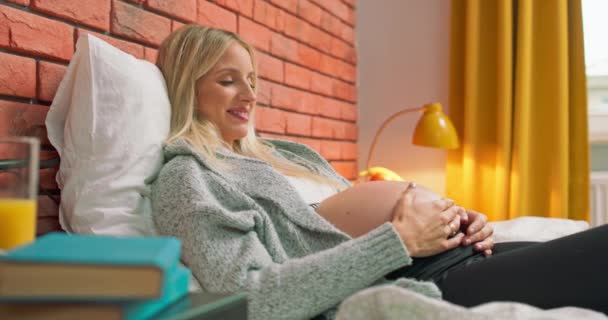 Portrait de mère attentionnée caresse un ventre nu enceinte avec deux mains, sur la chambre à coucher à — Video