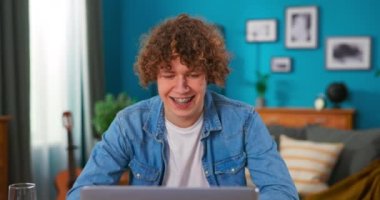 Genç çocuk sevinç dansı hareketleriyle çığlık atıyor. Harika haberlerle dolu bir e-posta alınca çok seviniyor.