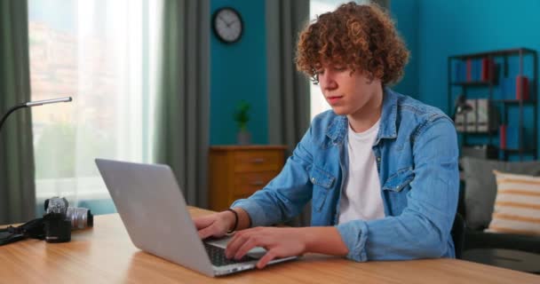 Éducation et études à la maison. Un jeune adolescent utilisant un ordinateur portable pour étudier, regarder — Video