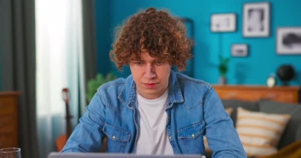 Úspěšný dospívající chlapec sedí u stolu používá notebook číst e-maily on-line domácí kancelář, dostane dobré — Stock video