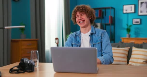 Úspěšný dospívající chlapec sedí u stolu používá notebook číst e-maily on-line domácí kancelář, dostane dobré — Stock video