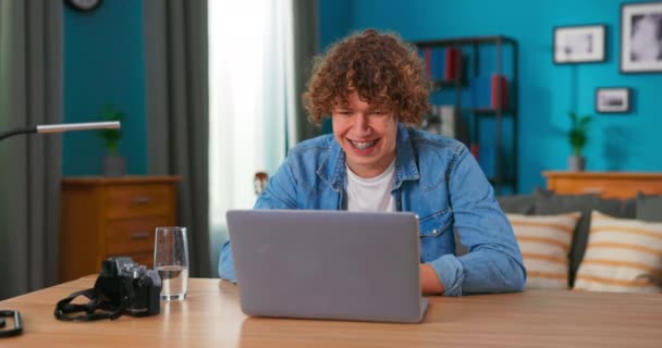 Lyckad tonårspojke sitter vid bordet använder laptop läsa e-post online hemmakontor, blir bra — Stockvideo