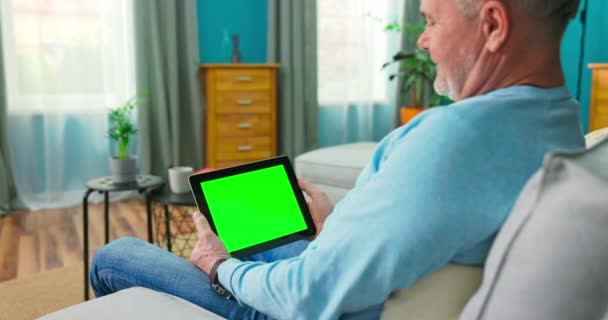 Senior man kiezen film uit online stream service met tablet. Kijken serie met op aanvraag — Stockvideo