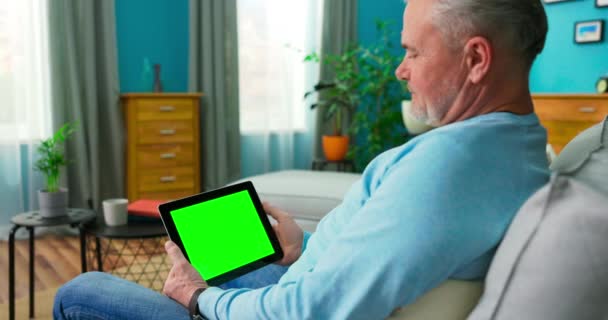 Homme plus âgé qui choisit le film à partir du service de streaming en ligne avec tablette. Regarder la série avec sur demande — Video