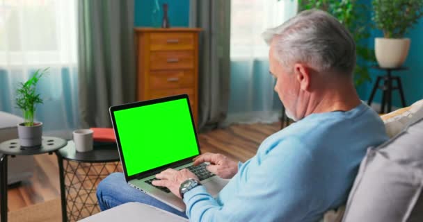 Mann tippt auf Tastatur auf grünem Bildschirm-Laptop-Computer — Stockvideo