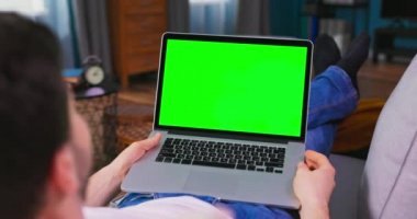 Talep videosu web sitesinde çok komik diziler izleyen bir adam. Erkek öğrenci yüksek sesle güler.