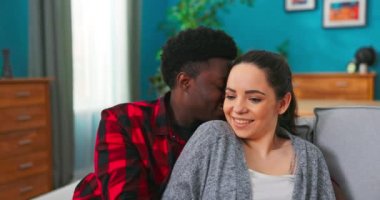 Mutlu çift birbirlerine bağlanıyor ve koltukta otururken gülümsüyor. Gülümsemenin portresi