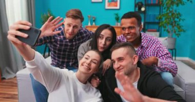 Dertsiz uluslararası çeşitli üniversite öğrencileri ışıl ışıl gülümseyip selfie çekimleri için poz veriyorlar.