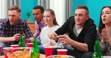 Neşeli melez ırklar, odada dinlenen arkadaşlar, oyun oynamak için joystick kullanıyorlar..