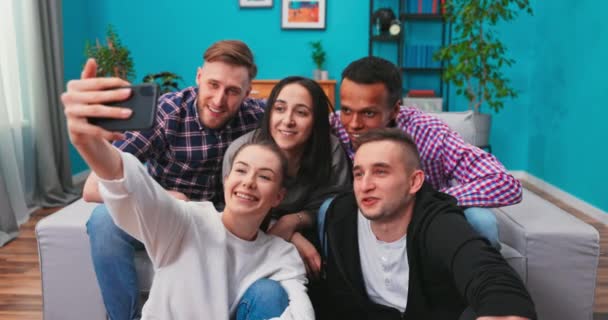 Spændt multietniske venner smilende, vinke og posere sammen til kamera, mens du gør gruppe selfie med – Stock-video