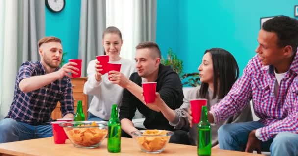 家庭での友人のお祝い、テーブルに集まった若い大人の多様なグループは楽しい時間を過ごす — ストック動画
