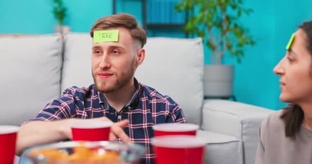 Een groep vrienden hangt rond in de woonkamer. Een blanke studente. — Stockvideo