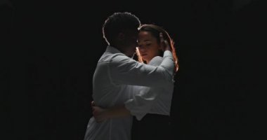 Sexy young elegant couple in tender passion, embrace each other, woman looks aside man kisses